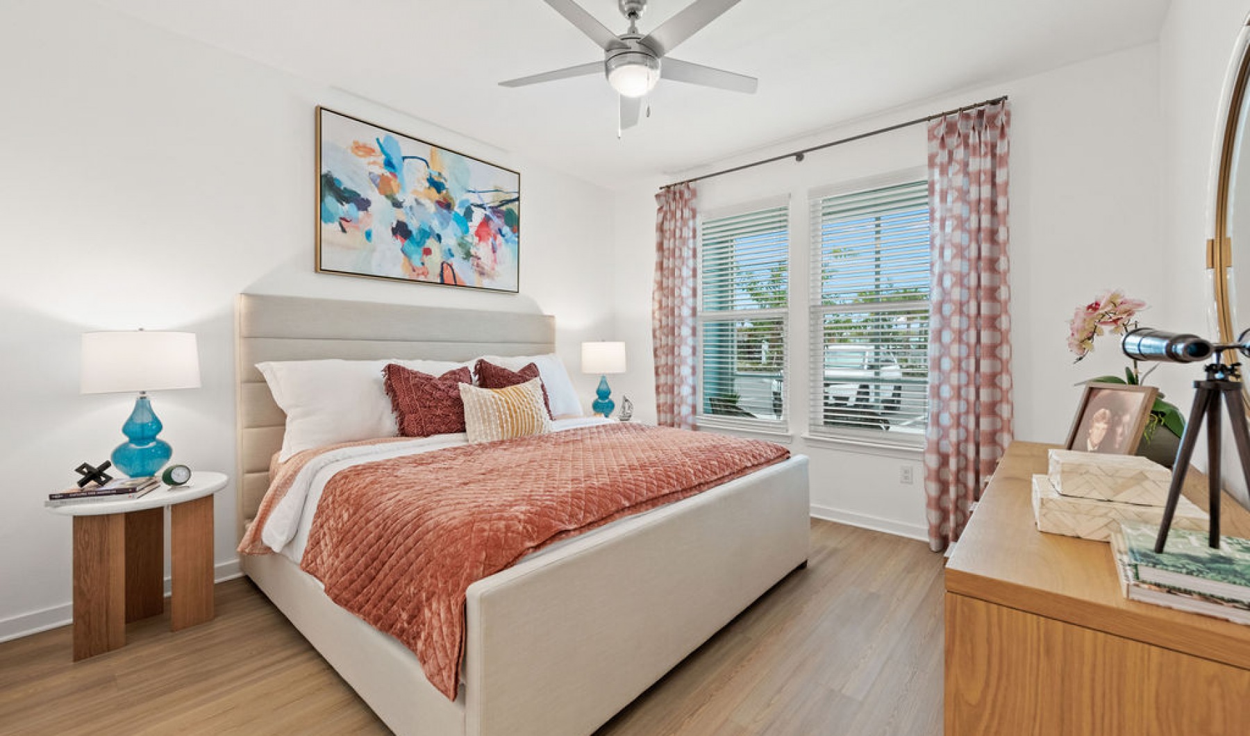Funished Vida Lakewood Ranch's apartment bedroom with ceiling fans and large windows 